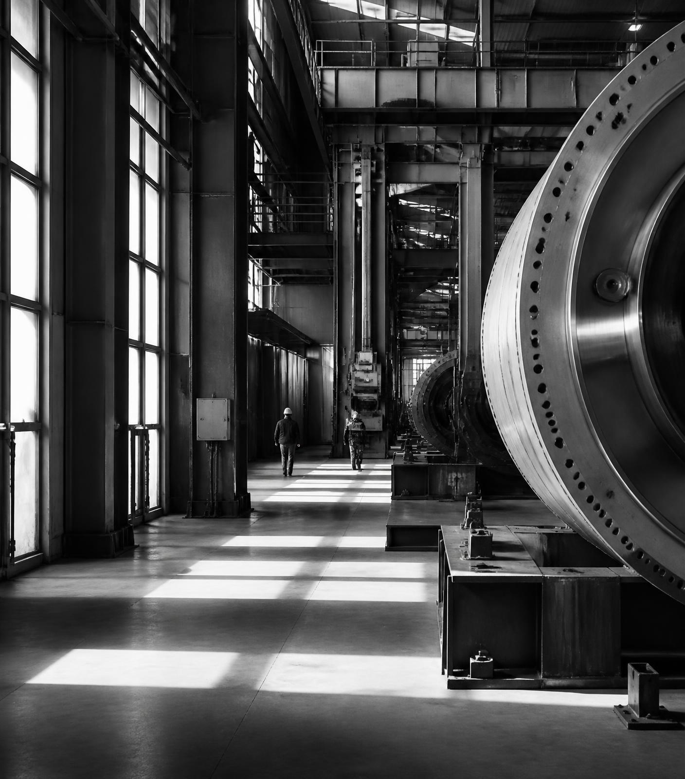 Interior de uma indústria moderna com máquinas em operação, em preto e branco